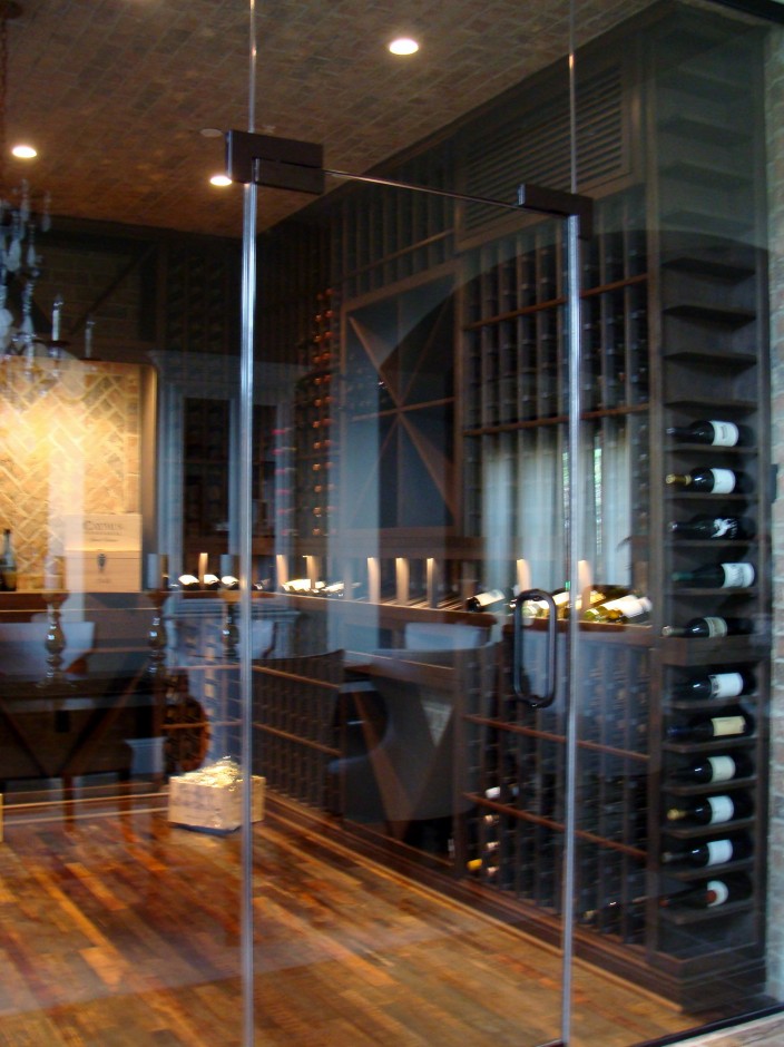 Seamless Glass Wine Cellar Door Provides a Clear View of the Wine Display in an Seattle Home