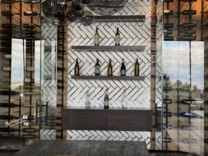 To match our modern wine racking, we used glass tiles as back paneling on the center of the wine cellar.